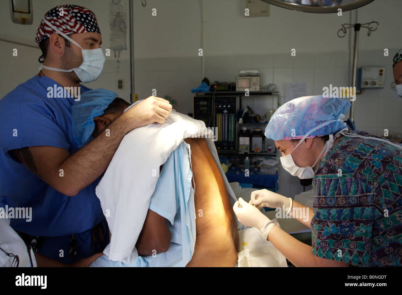 A nurse anesthetist administers a spinal injection while preparing a patient for surgery during a 2006 surgical mission to Sula Stock Photo