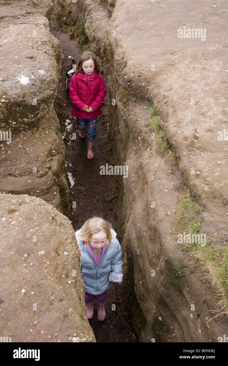 in the crack girls Two young girls explore a mine working crack in the rock at Alderley Edge.  Cheshire UK Stock Photo - Alamy