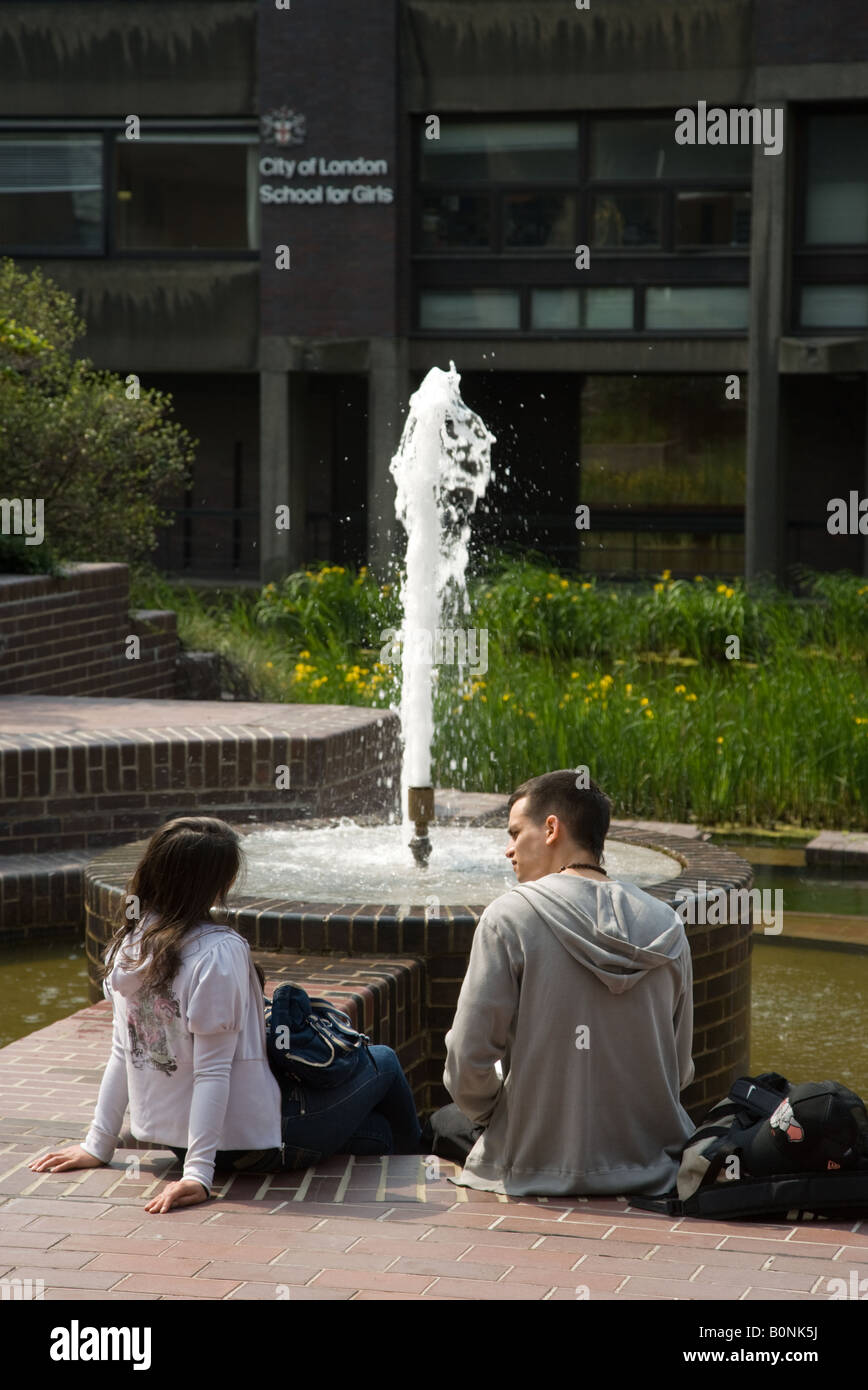 A young couple by a fountain in the Barbican Estate in Central London Stock Photo