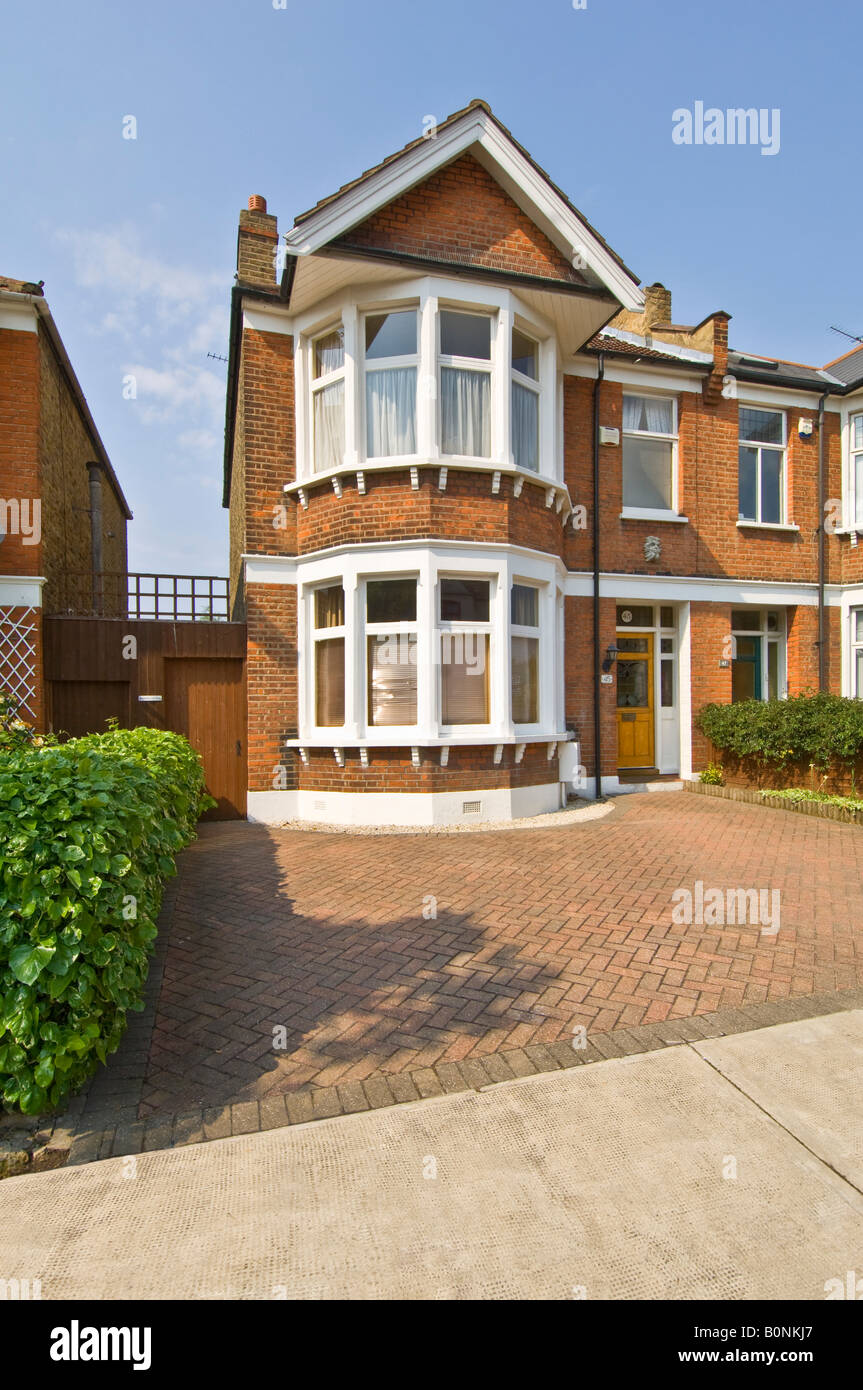 A typical 3 bed semi detached Victorian/Edwardian house in suburbia with a paved drive. Stock Photo