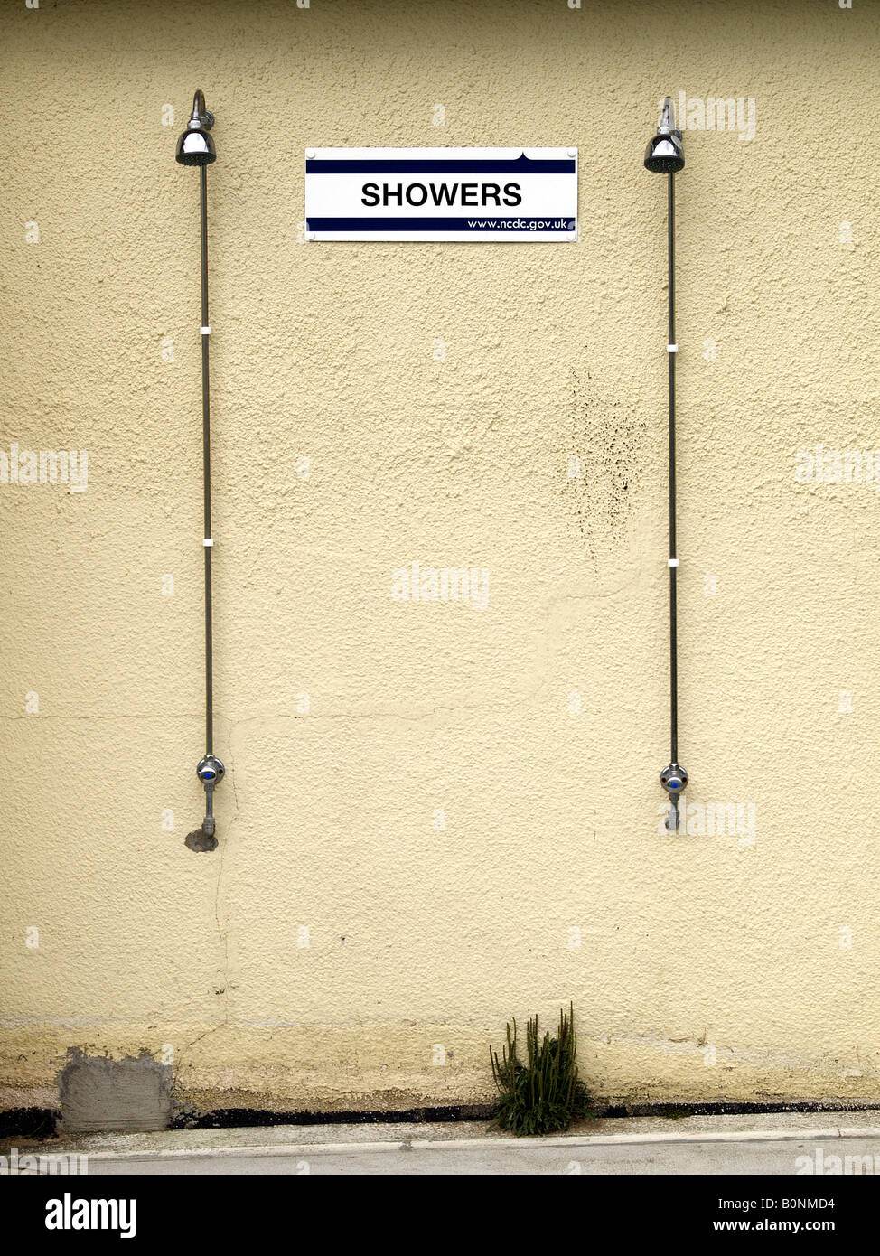 Outdoor showers attached to a yellowing wall Stock Photo Alamy