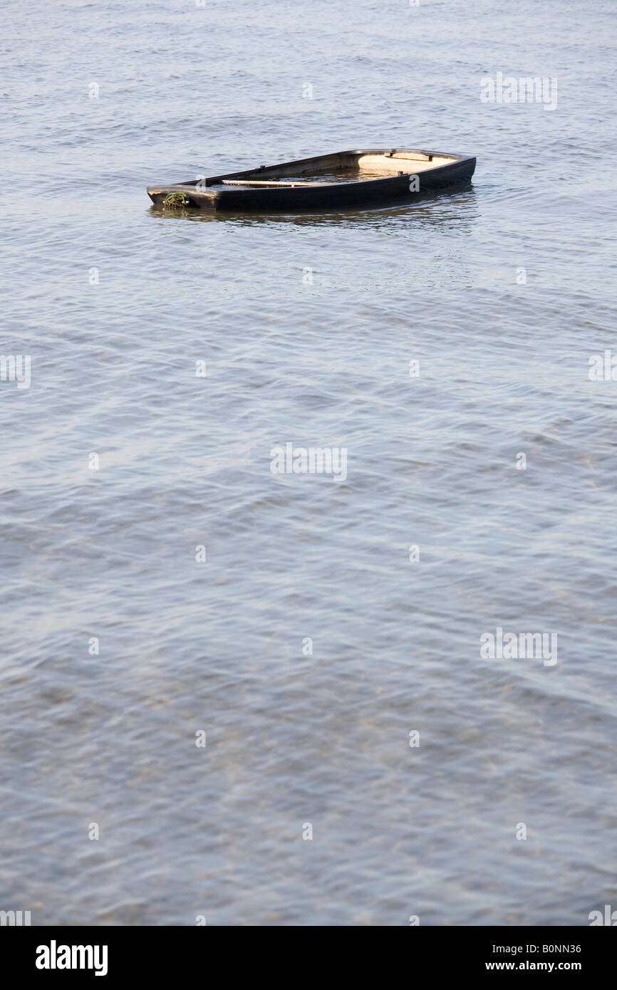 Swamped rowing boat moored in Poole Harbour Dorset UK Stock Photo