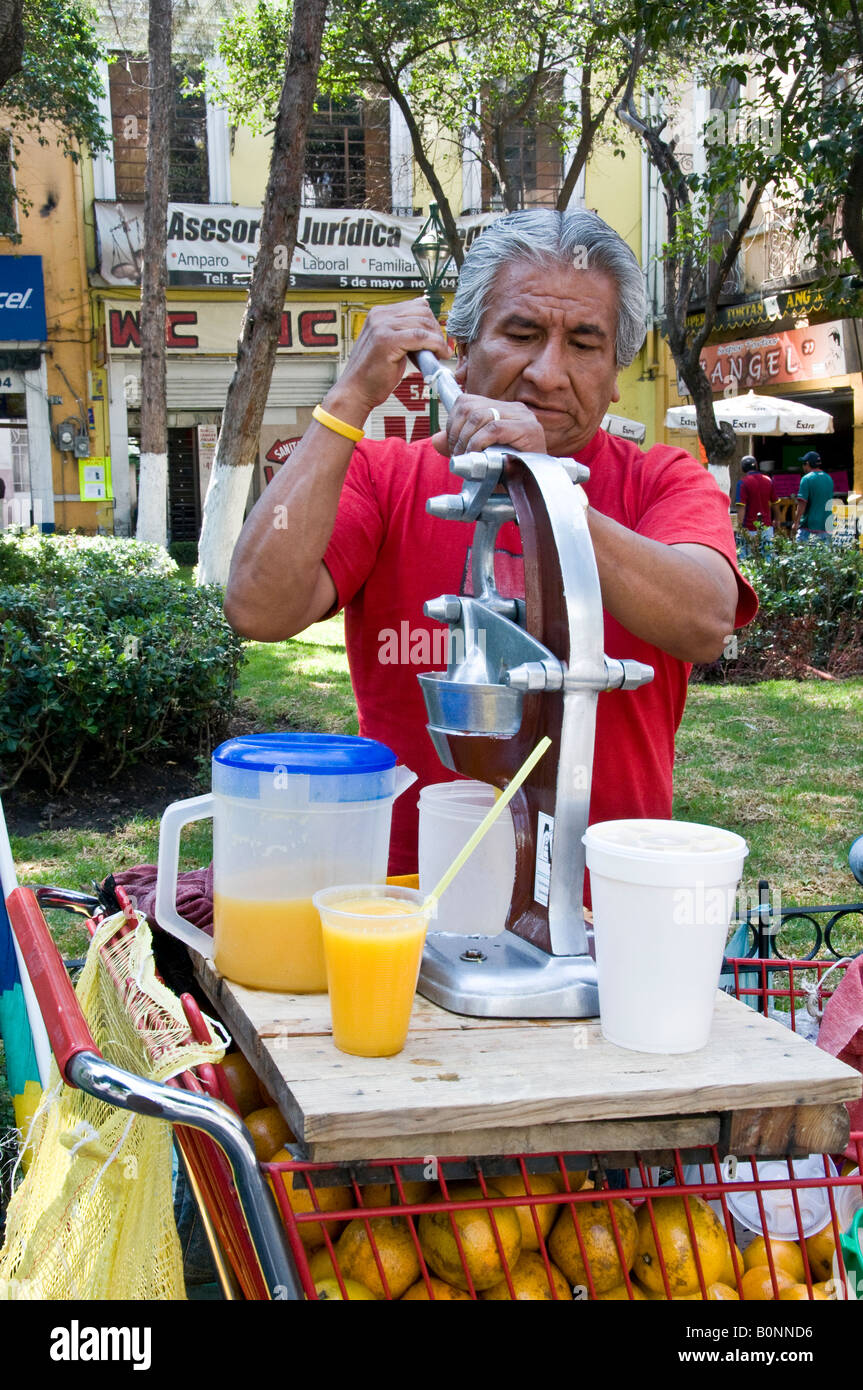 Mexican man squeezing orange juice for sale in market, Puebla, Mexico