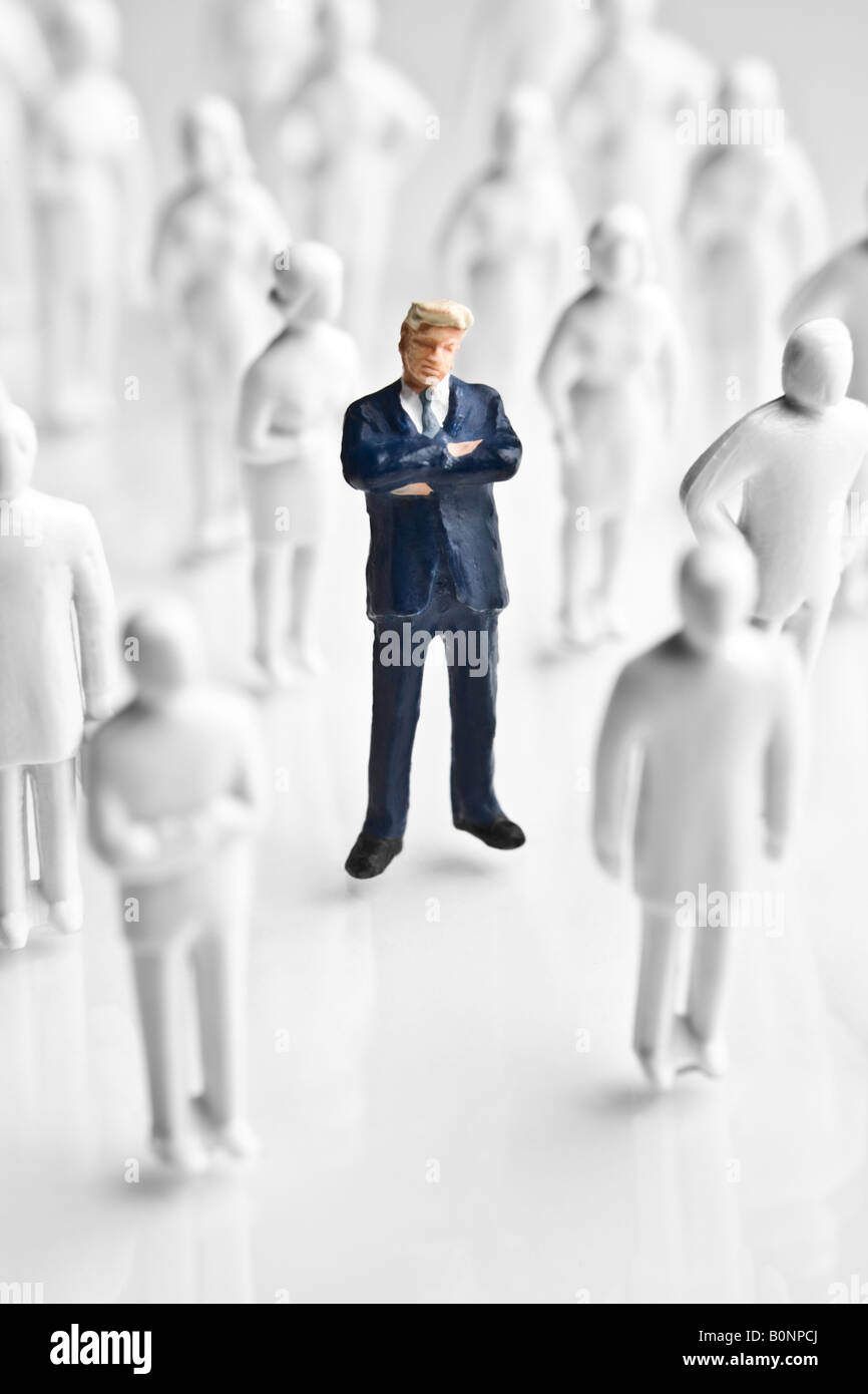 Businessman figurine surrounded by white, faceless figurines Stock Photo