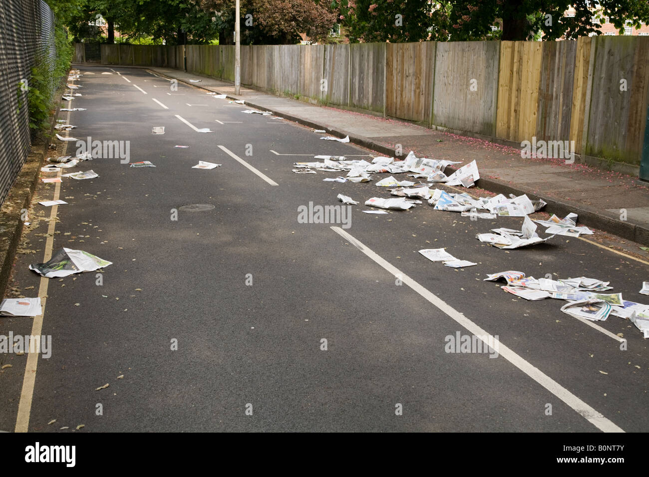 Newspaper and litter blowing down the road after it was placed for