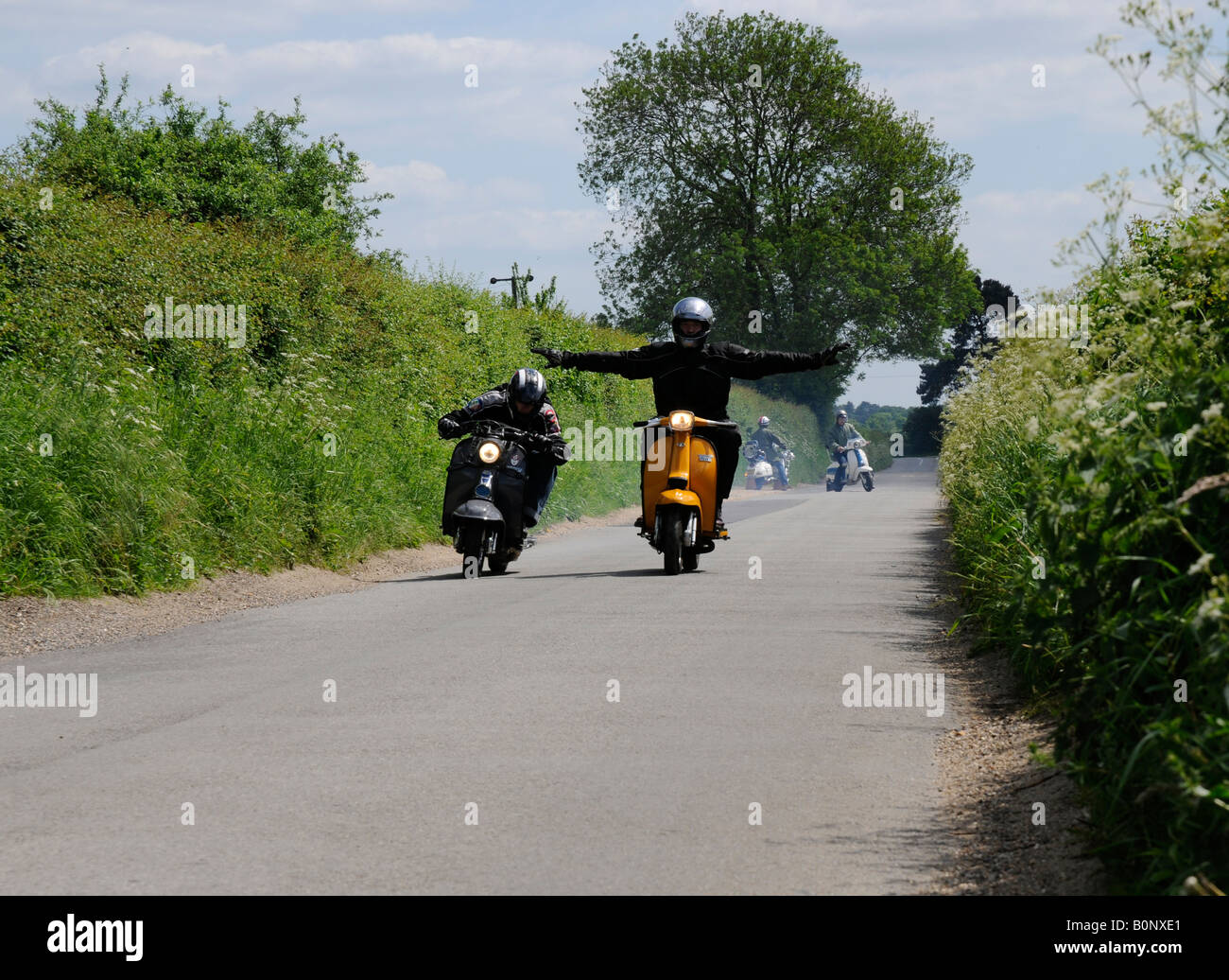Scooter riders having fun on a country lane Stock Photo