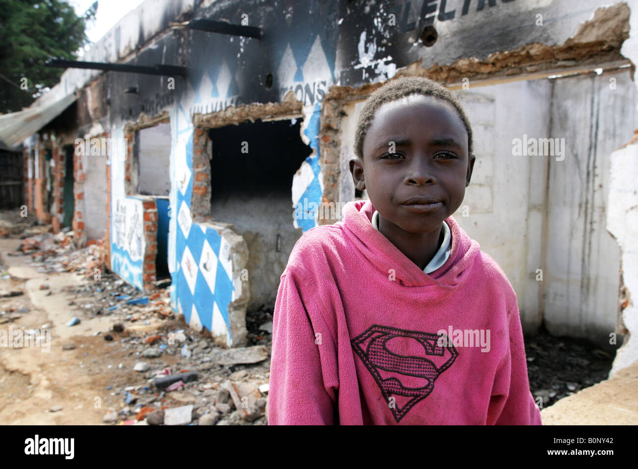 Kenya: boy sitting in front of a burnt house destroyed during the country's post-electoral violence in January 2008, Eldoret Stock Photo