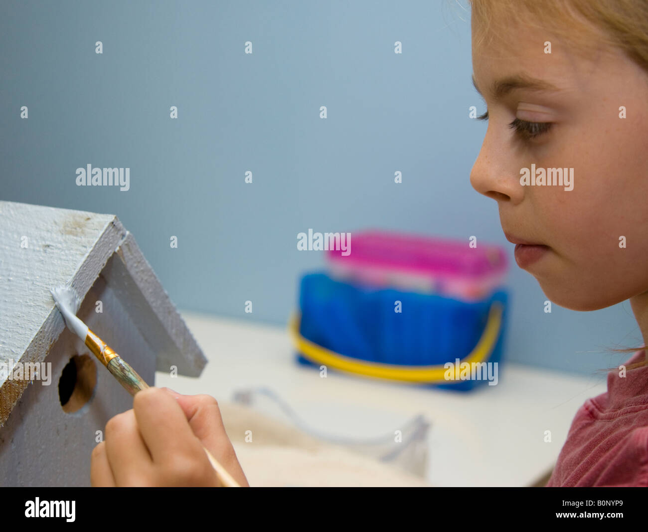 Child painting a birdhouse Stock Photo - Alamy