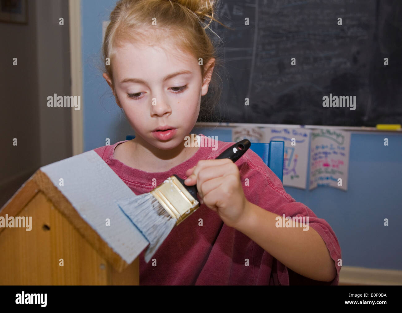 Child painting a birdhouse Stock Photo - Alamy