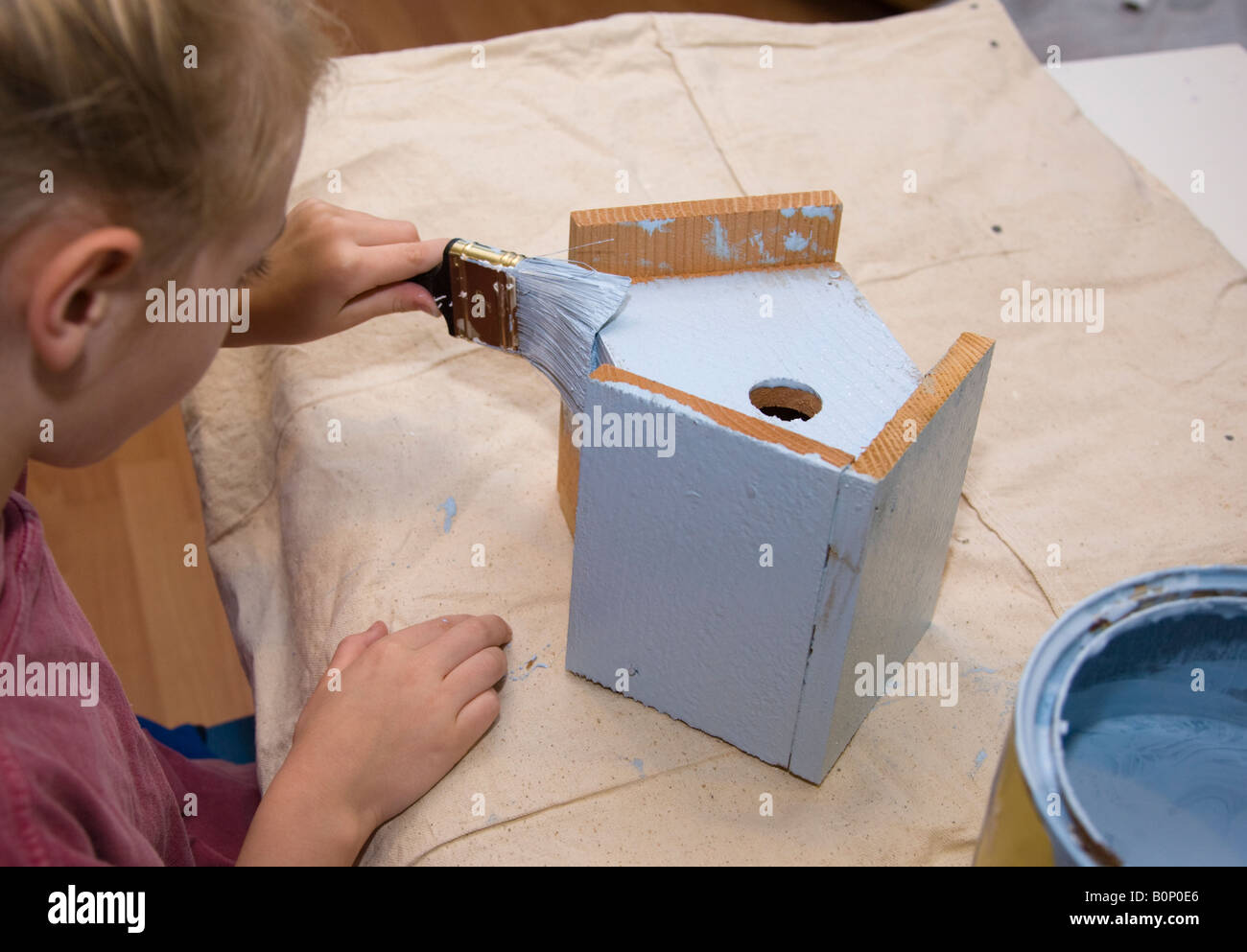 Child painting a birdhouse Stock Photo - Alamy