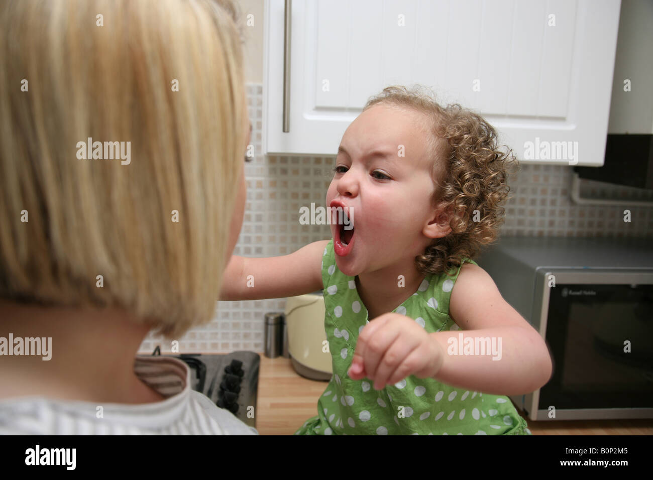 Toddler having a temper tantrum and screaming at her mother Stock Photo