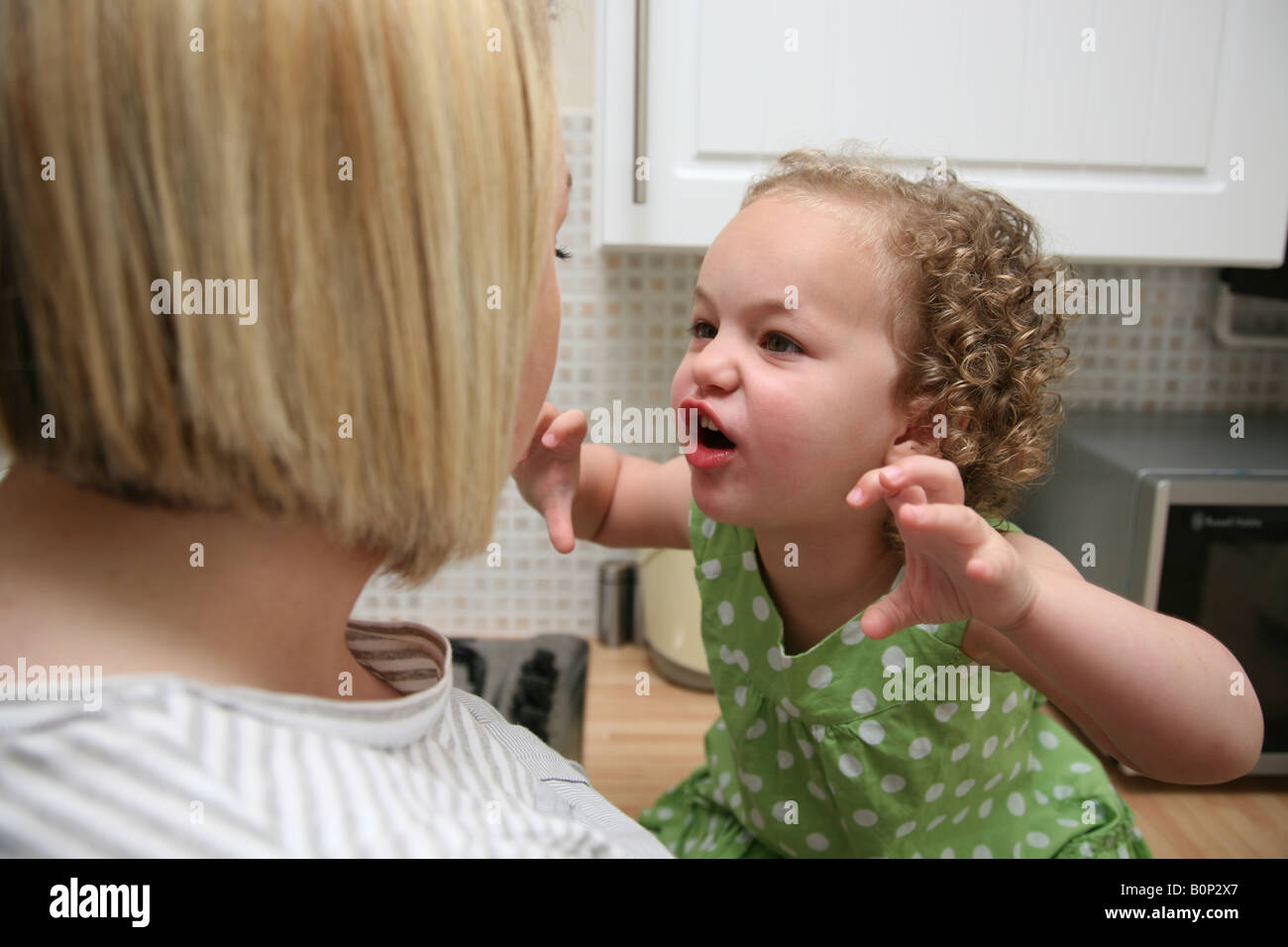 Toddler having a temper tantrum and screaming at her mother Stock Photo