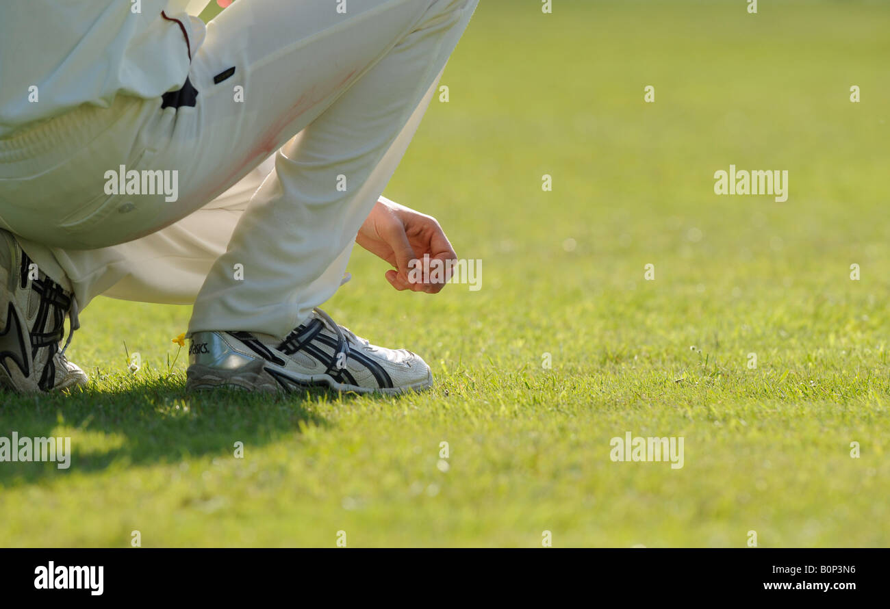 A fielder crouches waiting for action at cricket match in East Sussex. Picture by Jim Holden. Stock Photo