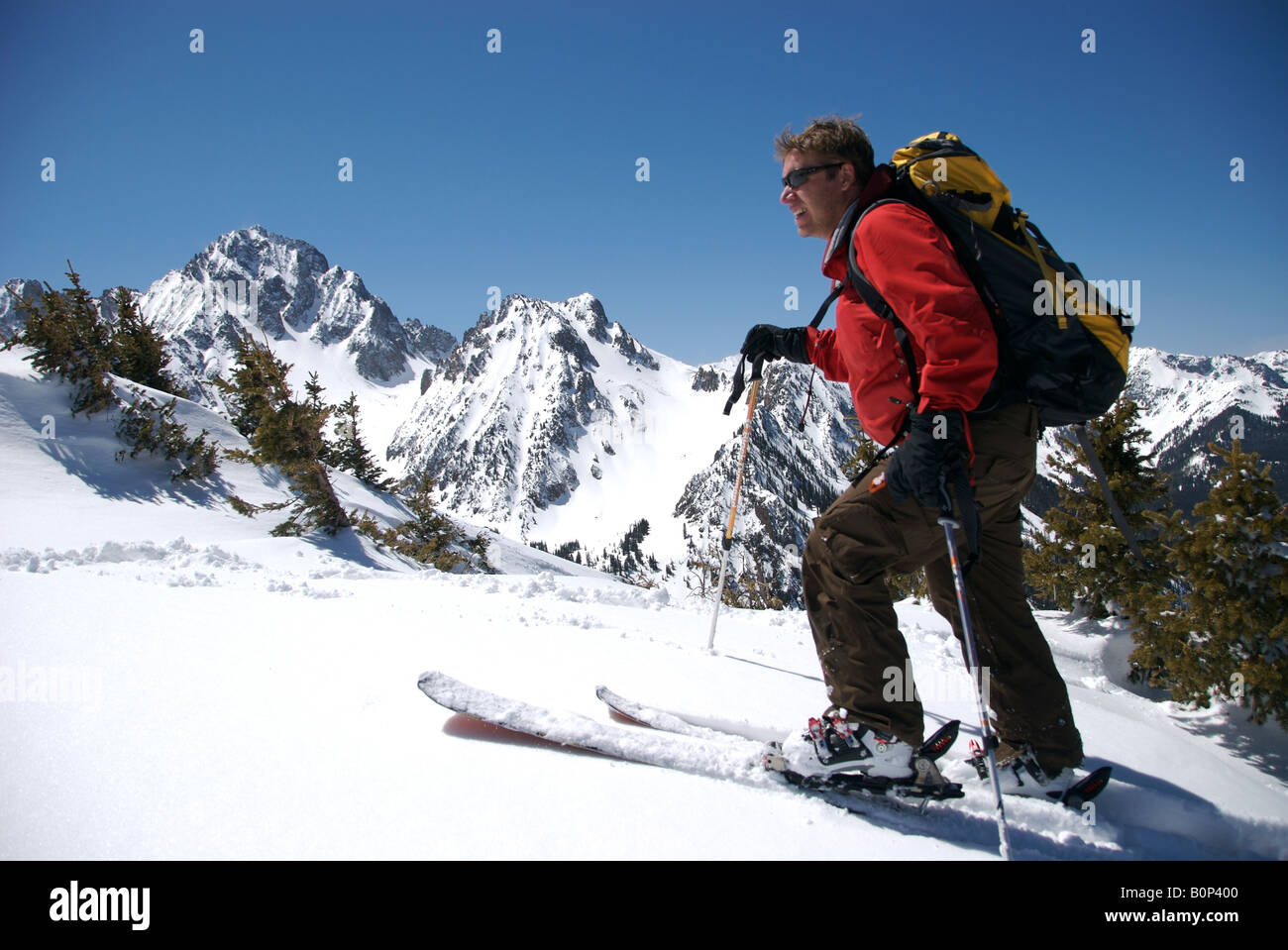 a man skins up a ridge to go backcountry skiing high up in the San Juan