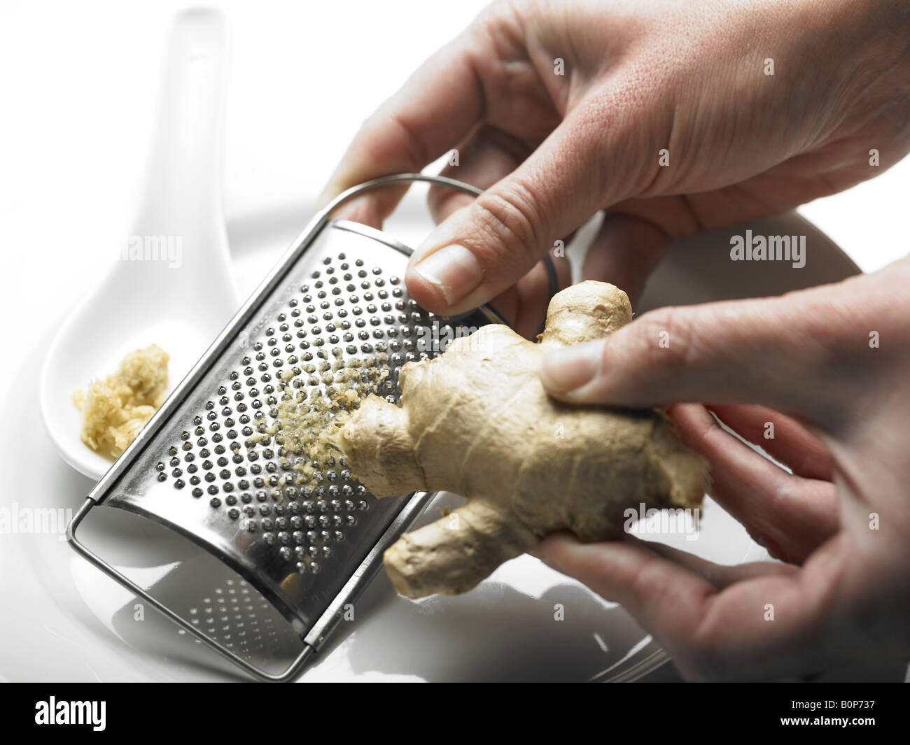person grating root ginger stem on grater Stock Photo Alamy
