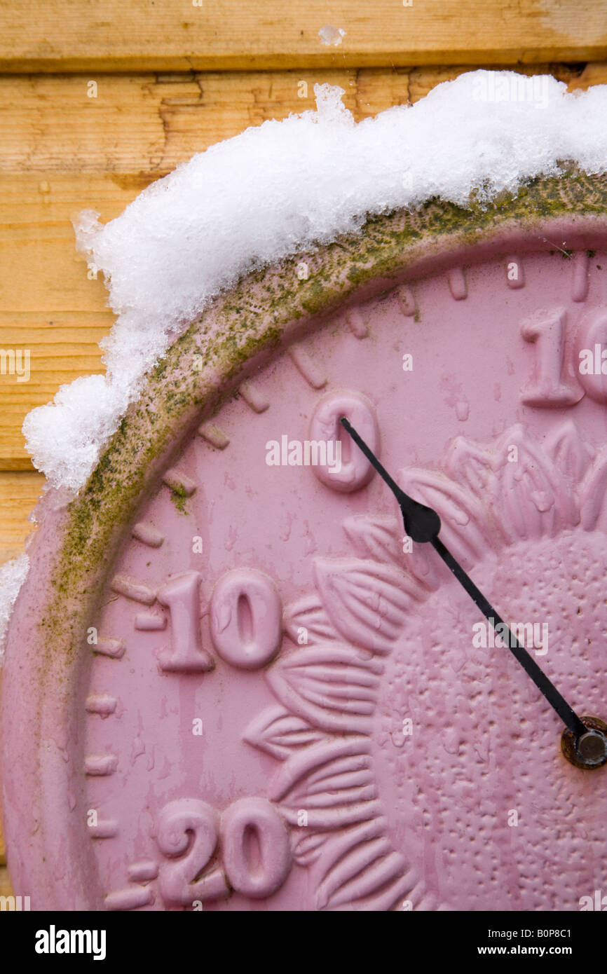 Garden thermometer showing freezing point in snow. UK Stock Photo