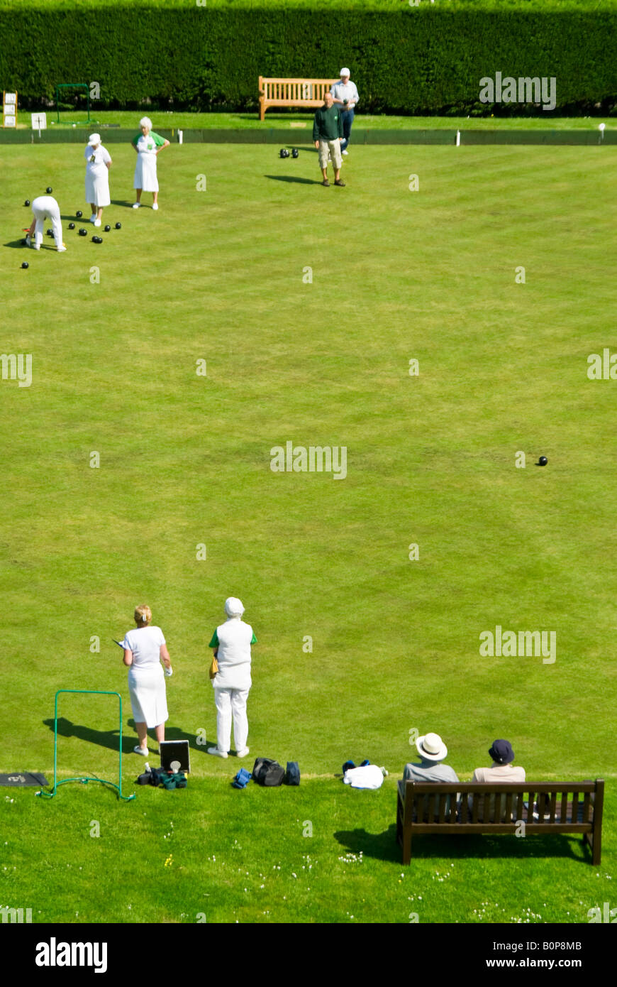 Vertical elevated view of competing teams playing an end in a game of bowls on a sunny day. Stock Photo