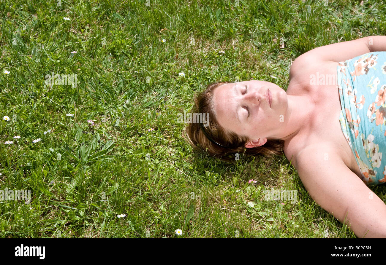 Woman laying in the grass enjoying the sun Plenty of copyspace Stock Photo