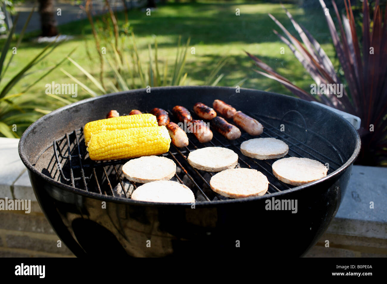 Cooking Thick Pork Sausages On An Outdoor Summer BBQ In The Garden