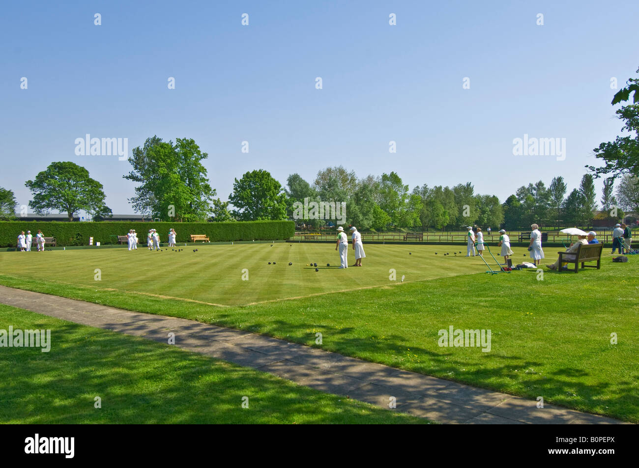 An wide angle view of elderly people during a bowls match on a sunny day in Rye. Stock Photo
