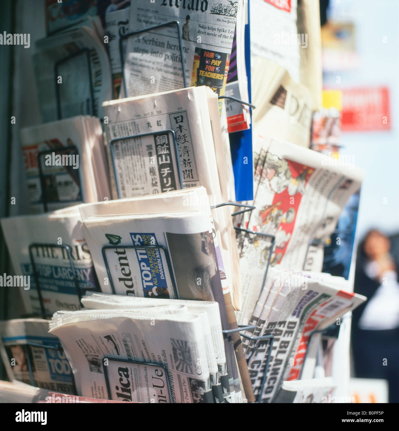 Newspaper stand selling international foreign newspapers for sale on a paper display rack outside newsagents shop in London, England UK  KATHY DEWITT Stock Photo