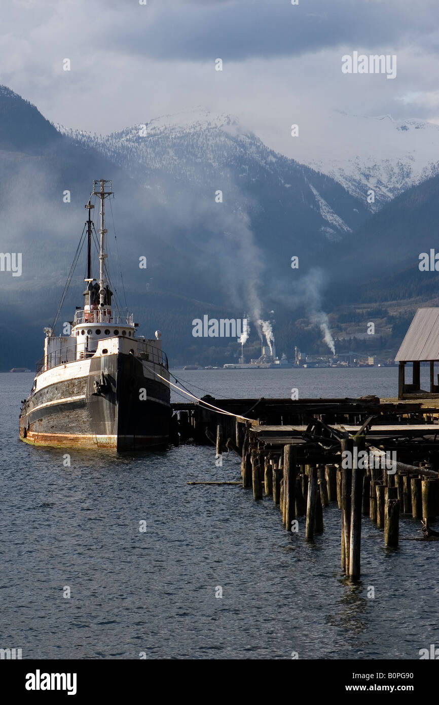 An old boat tied up at Britannia Beach with the working pulp mill in