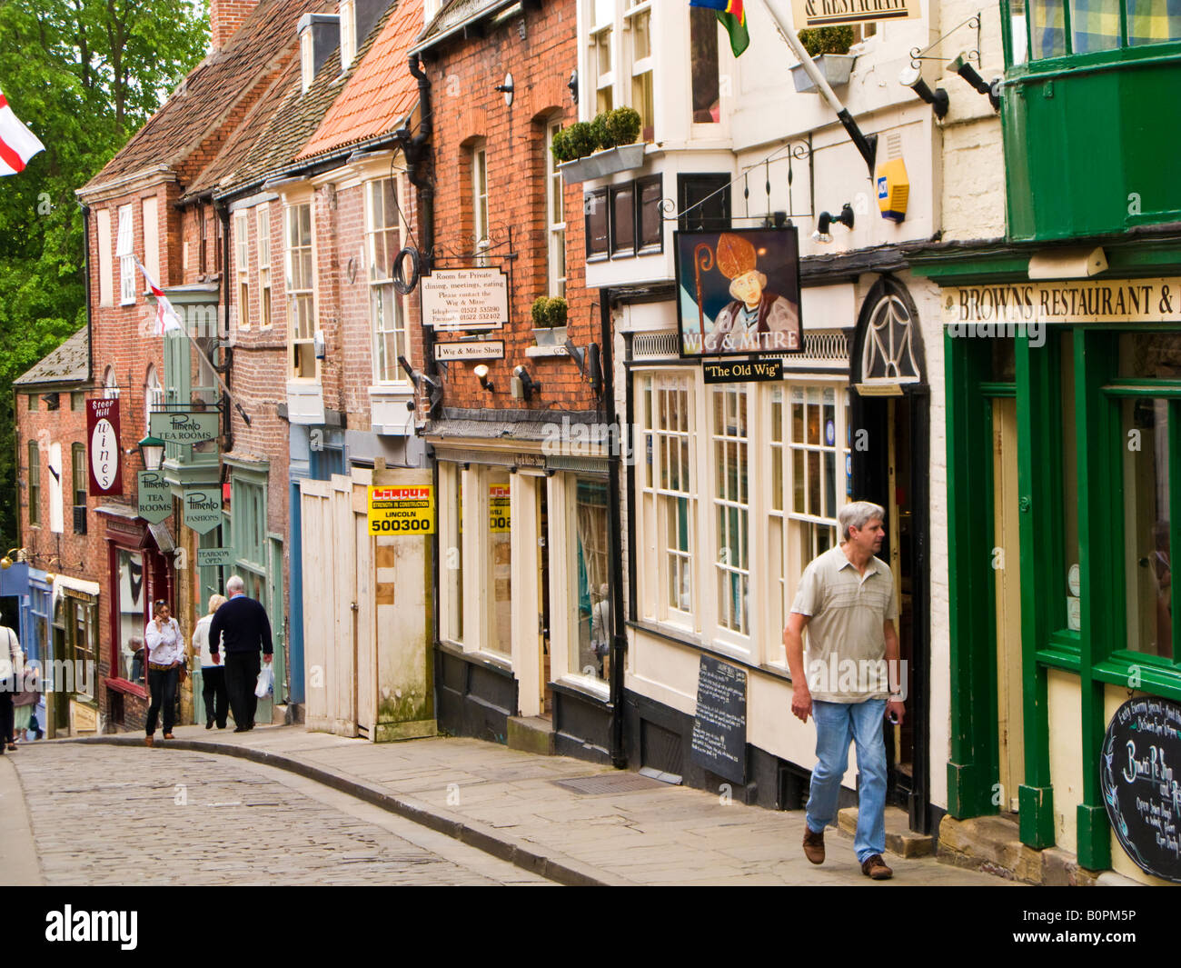 People in Lincoln city UK walking on Steep Hill past a traditional pub and tea room, Lincolnshire, England, UK Stock Photo