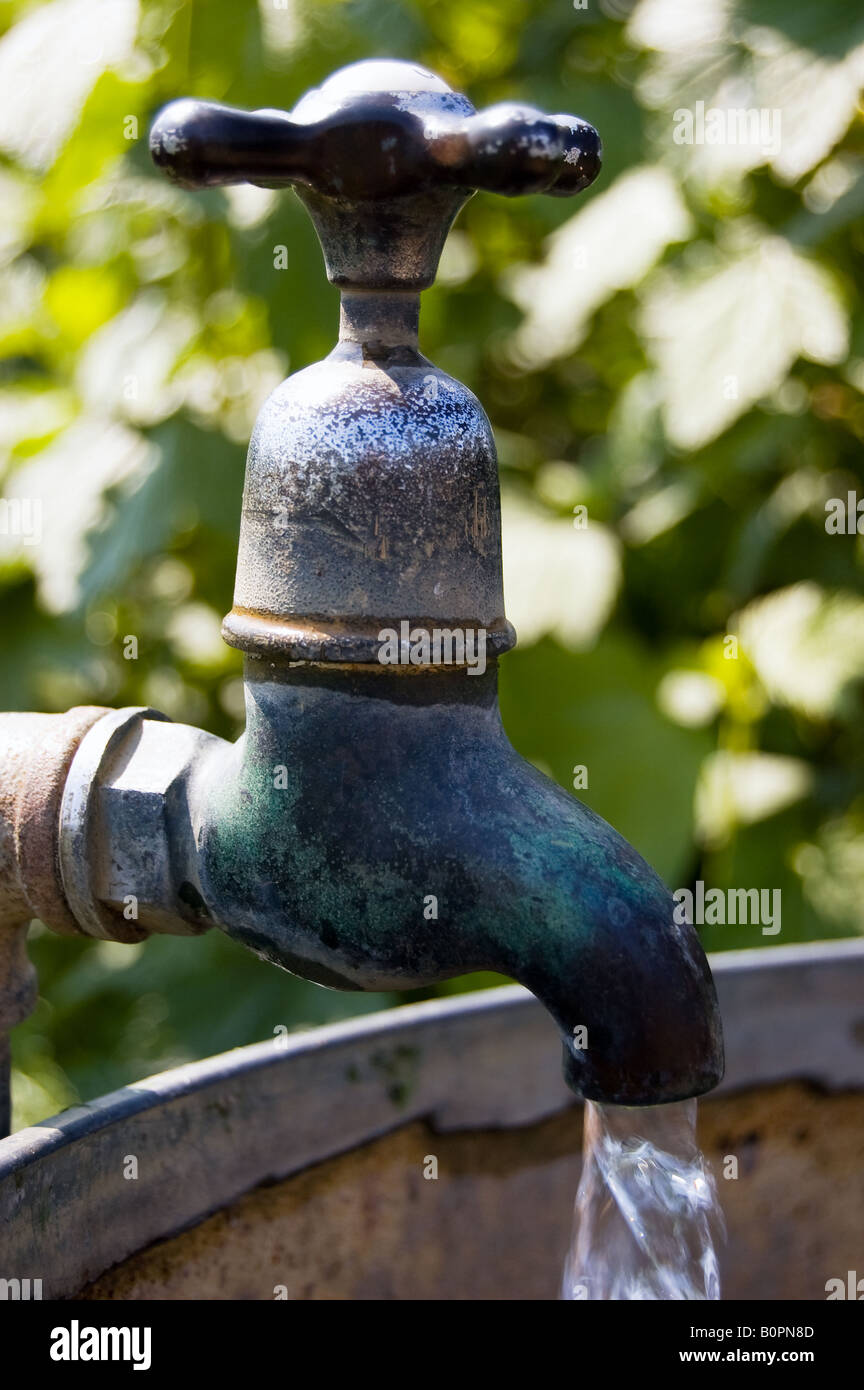 A running tap on an outdoor water container Stock Photo Alamy