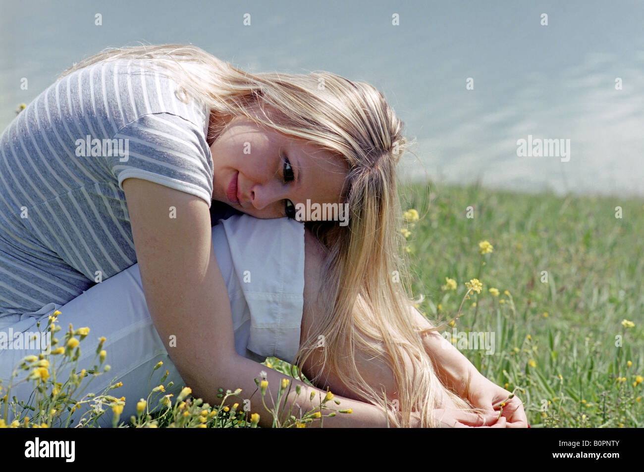 young woman sitting  on grass Stock Photo