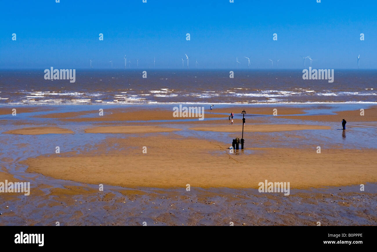 View of the sandy beach at Skegness in Lincolnshire England with an offshore wind farm visible on the horizon Stock Photo