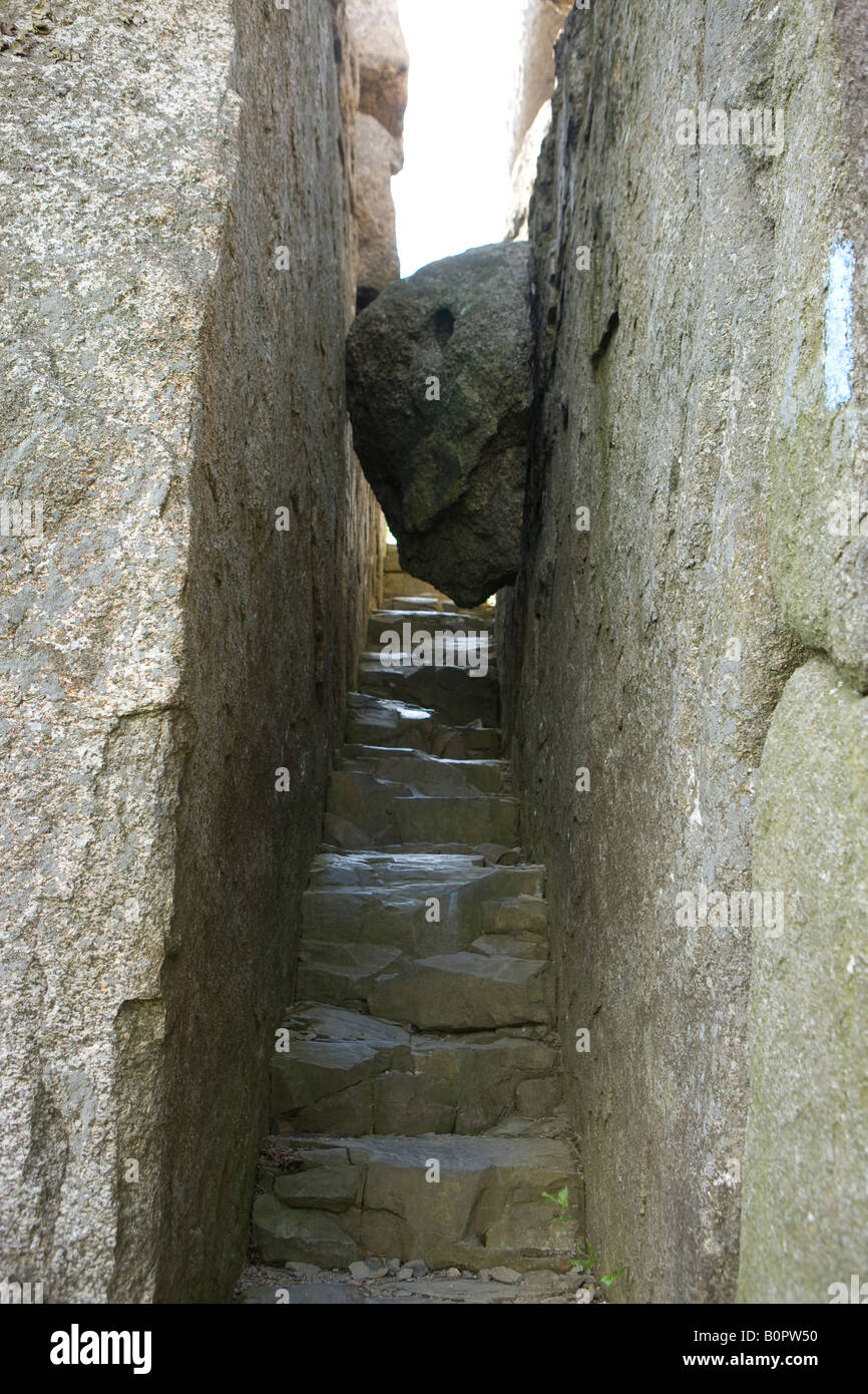 A boulder is wedged on between a granite staircase on the Ridge Trail to the summit of Old Rag Mt Shenandoah National Park VA US Stock Photo
