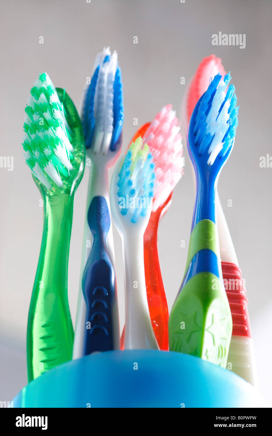 An assortment of toothbrushes for the whole family sit on a bathroom ...