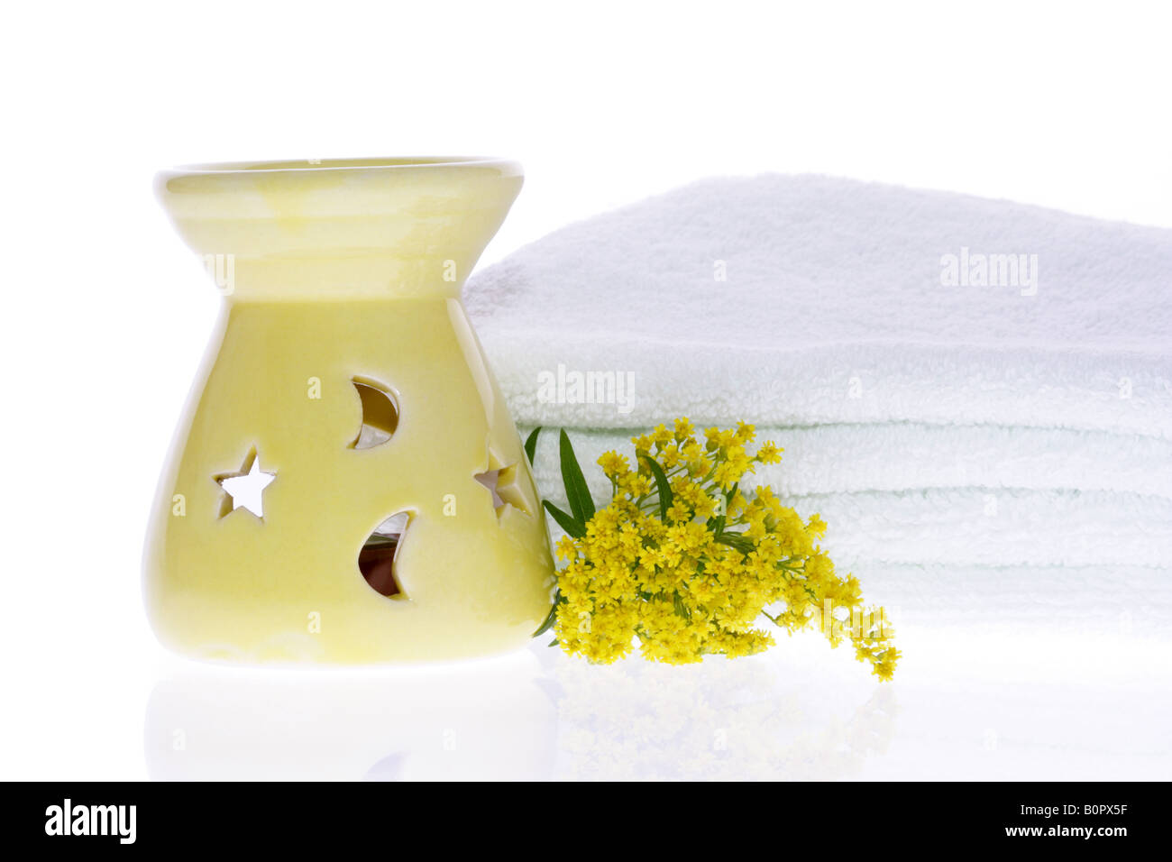 Oil Burner Yellow Flower and White Towel on White Background Stock Photo
