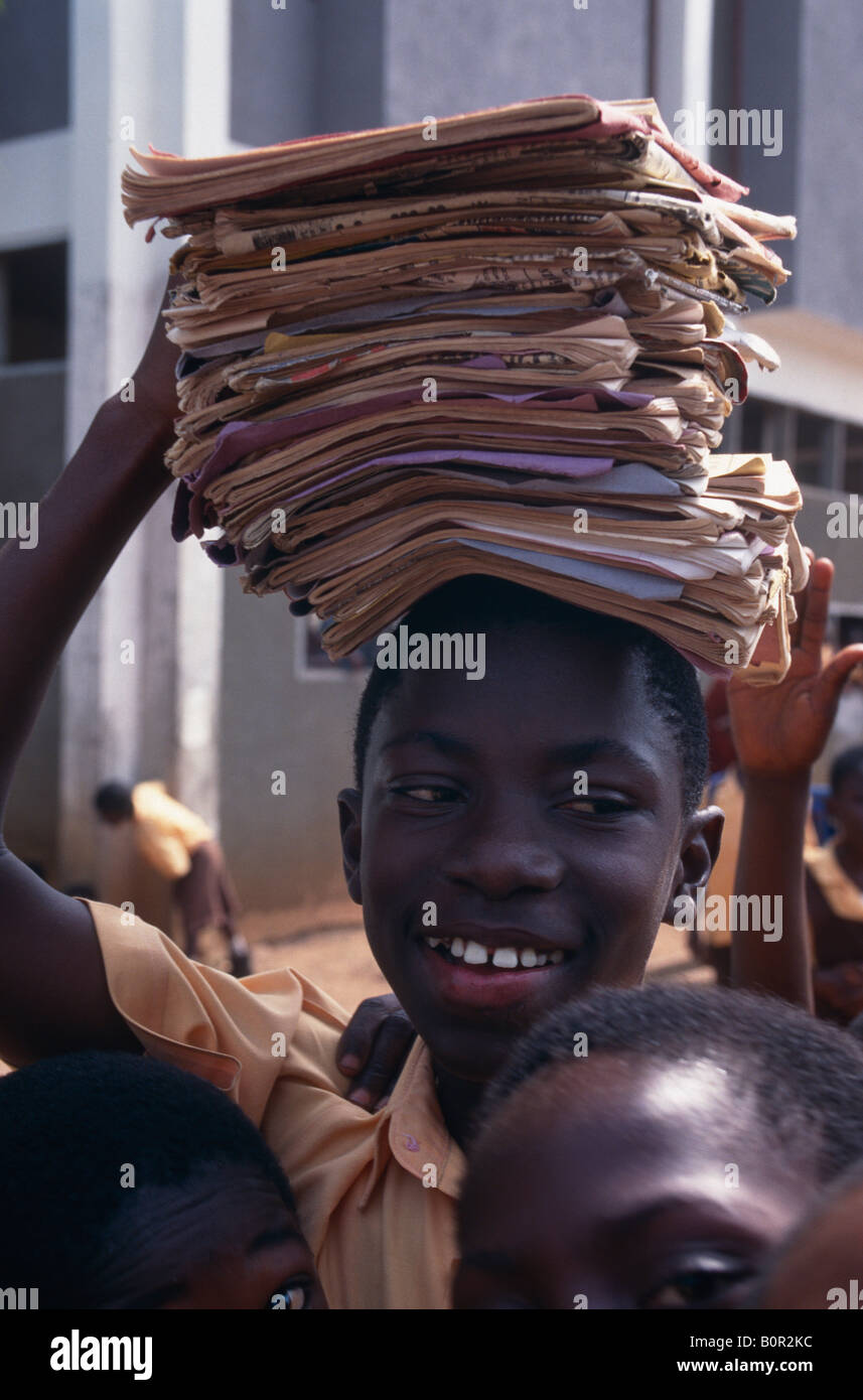 Carrying exercise books on his head a boy at Okuapemman School Akropong in Ghana Stock Photo