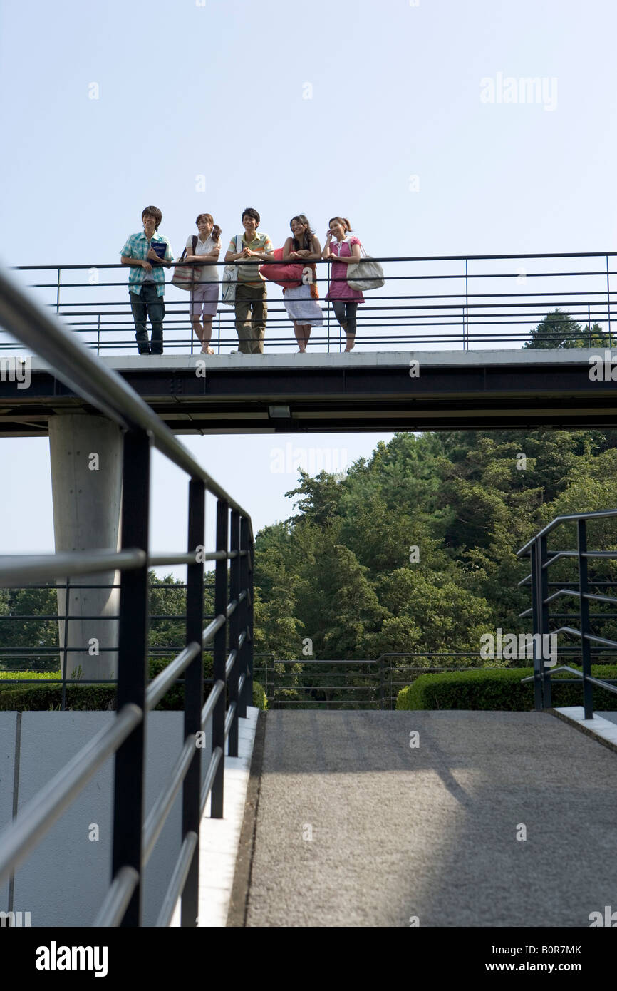 Five young people leaning on railing Stock Photo