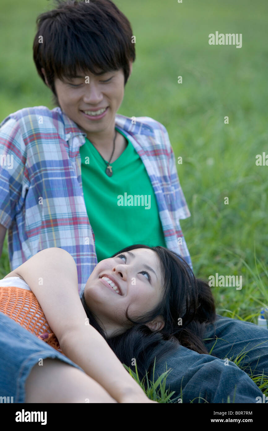 Young couple relaxing on grass Stock Photo - Alamy