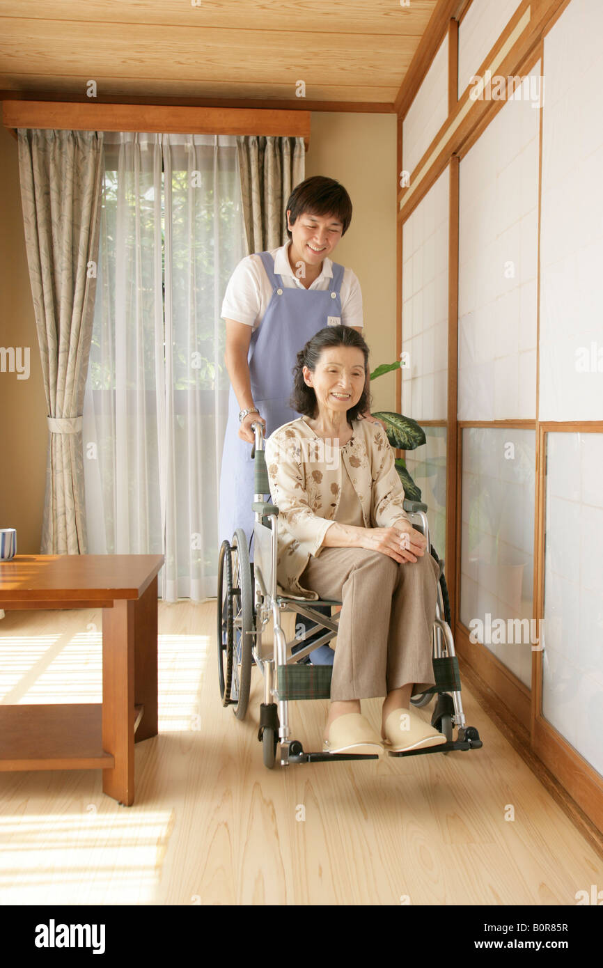 Female nurse pushing elderly woman in wheelchair Stock Photo - Alamy