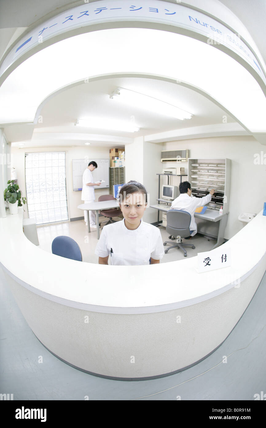 Portrait of female nurse at hospital counter, fish eye lens Stock Photo