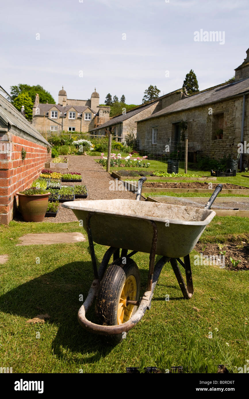 UK England Lincolnshire Easton near Grantham Easton Hall Garden wheelbarrow in cottage garden Stock Photo