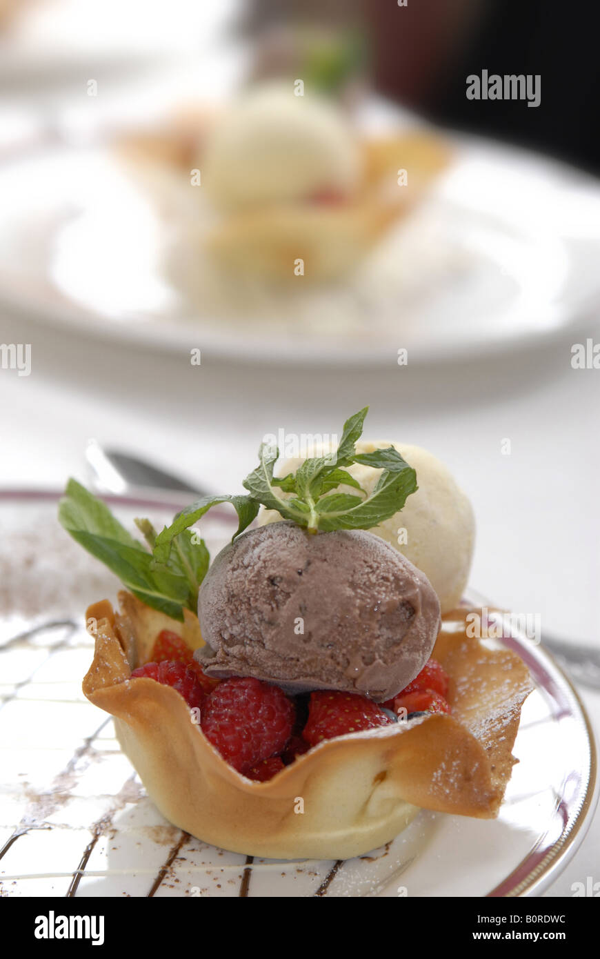 A Sweet Basket Of Strawberries And Ice Cream With A Sprig Of Mint