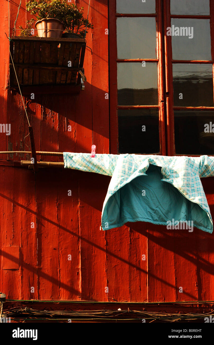 A Chinese jacket hung to dry outside a window Stock Photo
