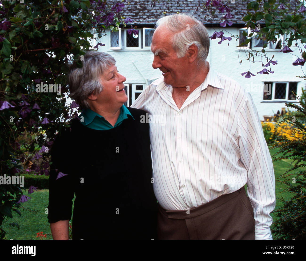Senior couple in front of their home Stock Photo