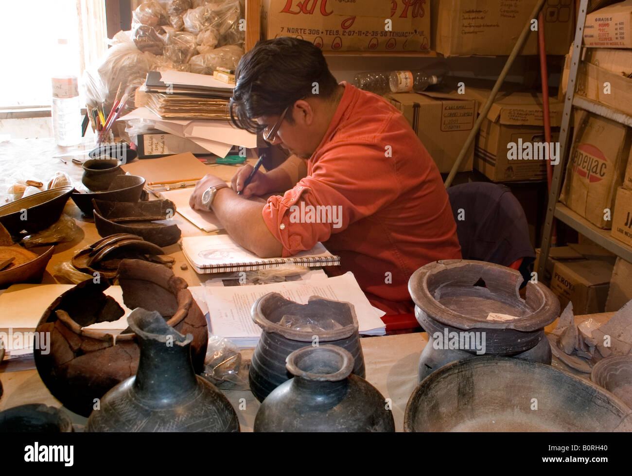 An archaeologist draws ceramic artifacts found in an 8th century AD Mesoamerican pre-Columbian village site in Oaxaca Mexico Stock Photo
