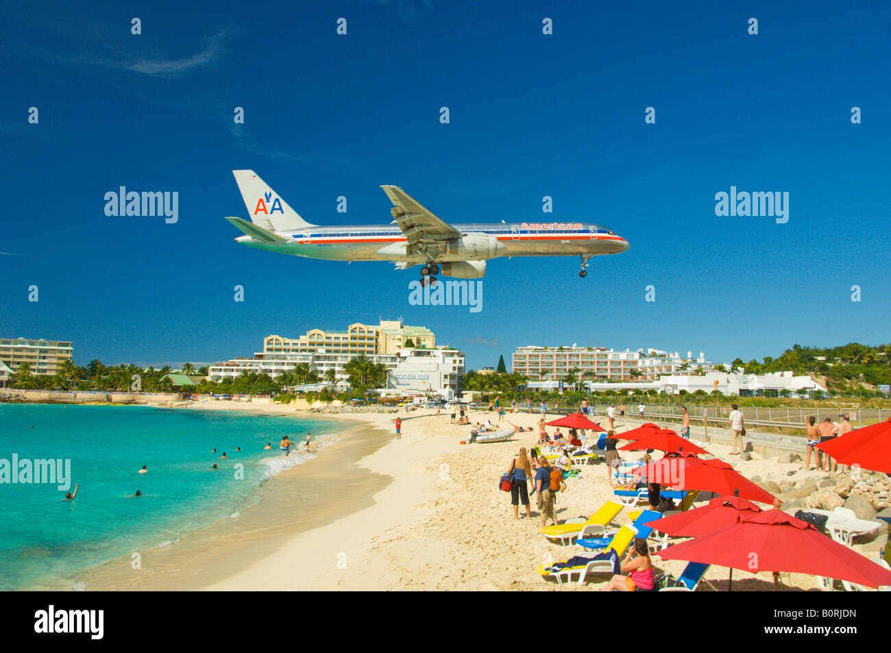 An passenger plane landing over Maho Beach Sint Maarten Netherland Antilles Stock Photo