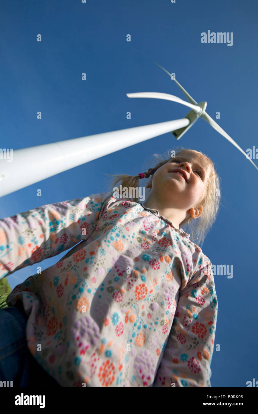 A young girl close to a windmill (France). Fillette devant une éolienne (France). Stock Photo