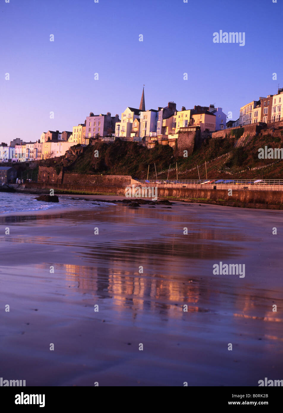 North Beach Tenby at dawn with houses reflected in wet sand Pembrokeshire West Wales UK Stock Photo