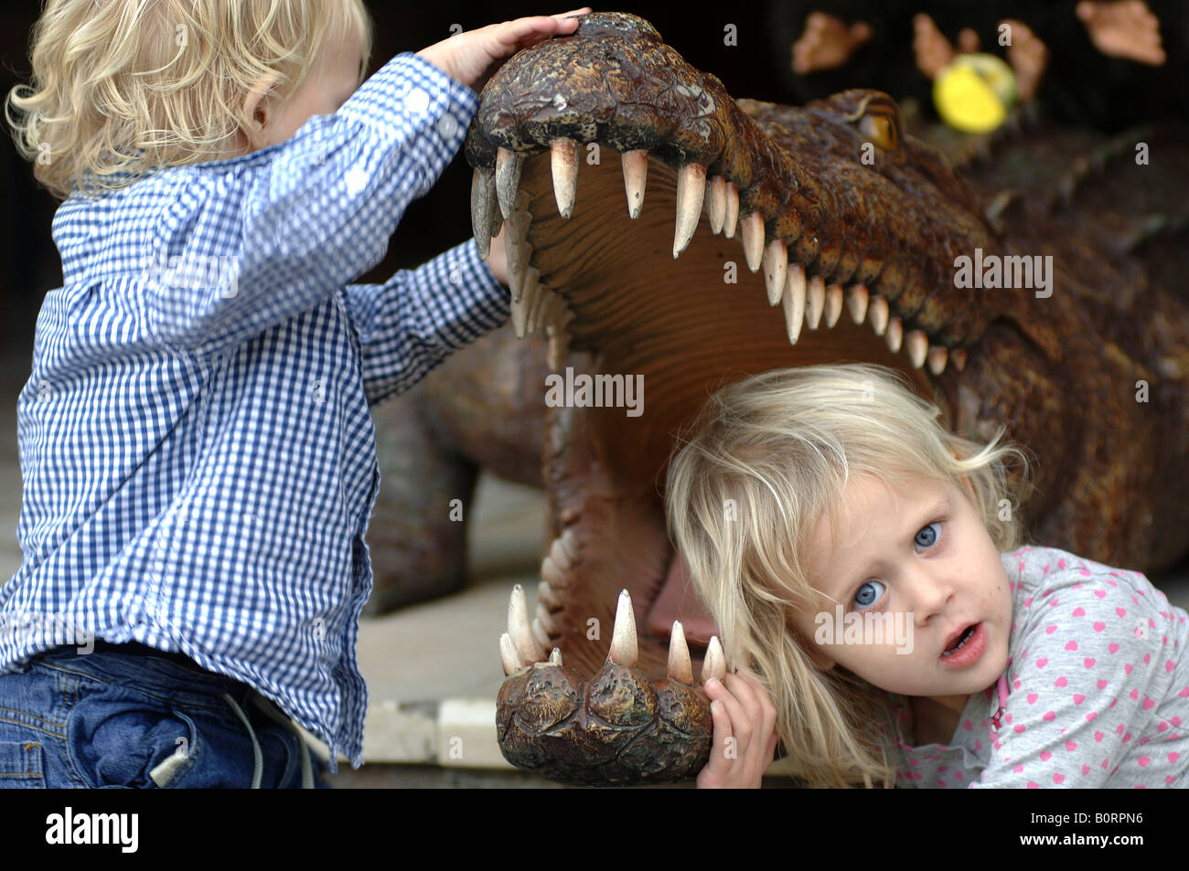 Gran Canaria children playing with a stuffed crocodile in a restaurant in Puerto de Mogan Stock Photo