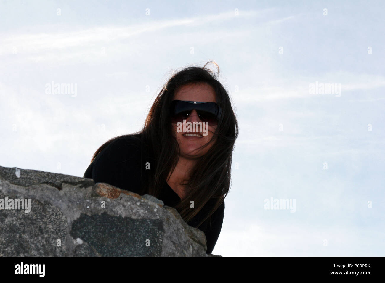 Young model portrait on the stone fence in the cliffs of Cedeira, La Coruña, Spain. Stock Photo