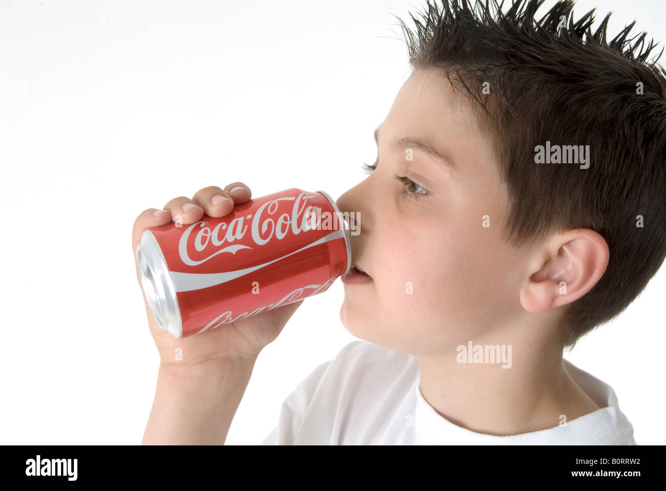 boy child young drinking coke a cola can tin pop red coke can drink drinking drinker marketing american brand iconic logo design Stock Photo
