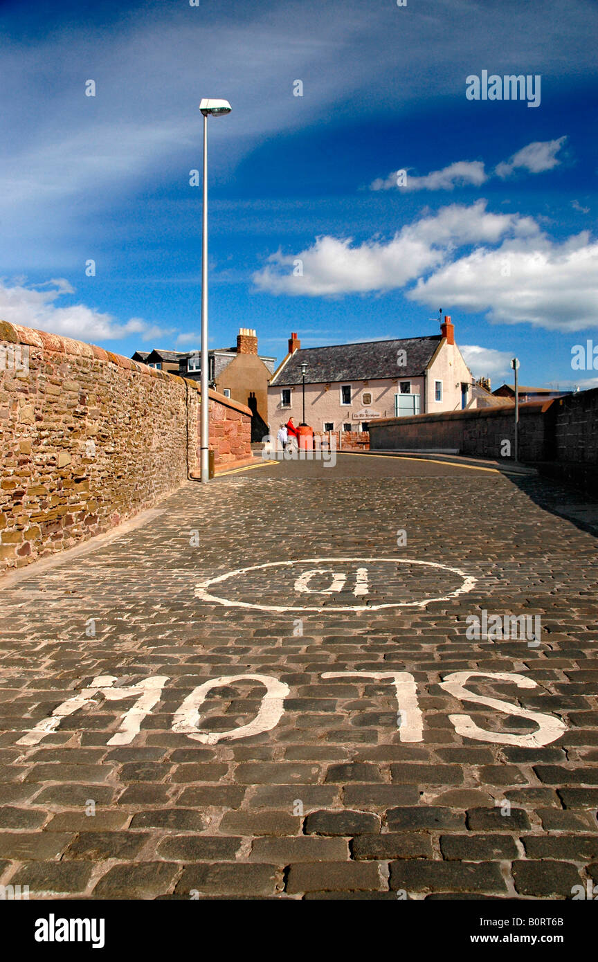 A 'slow 10 mile/hour' sign on cobbled stones near the harbour at Arbroath, Angus. Stock Photo